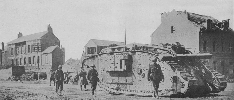 Британский танк идет через деревню